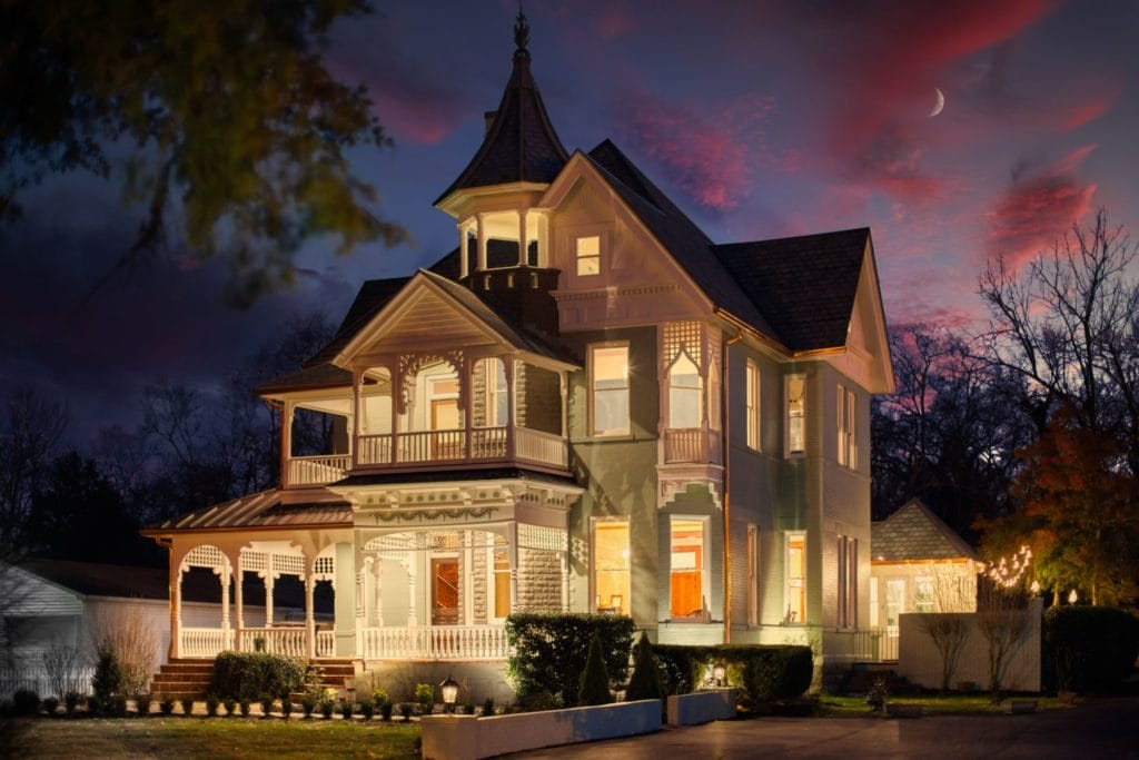 An old victorian home photograph at night, renovated by Reid & Co. Construction